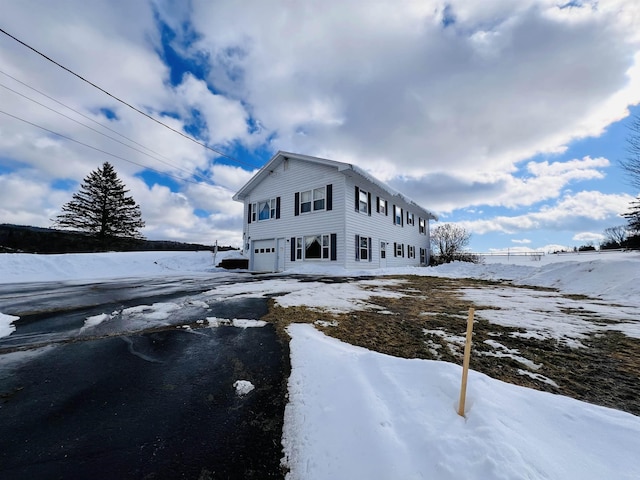 view of snowy exterior featuring a garage