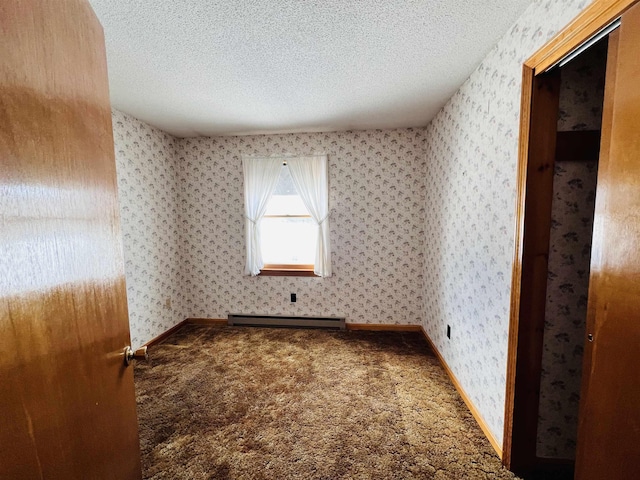 carpeted spare room with a baseboard heating unit, a textured ceiling, and wallpapered walls