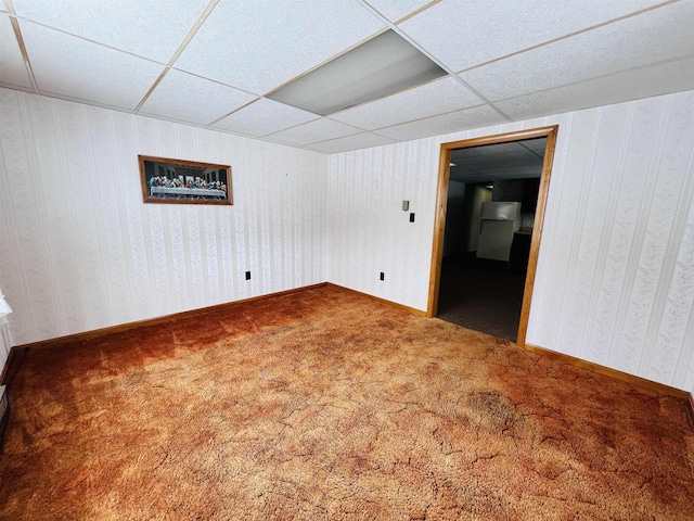 interior space featuring wallpapered walls, baseboards, and a drop ceiling