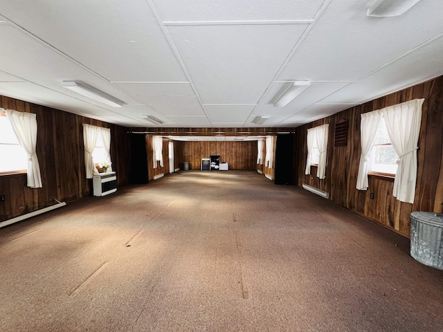 misc room with plenty of natural light, heating unit, a baseboard radiator, and wooden walls