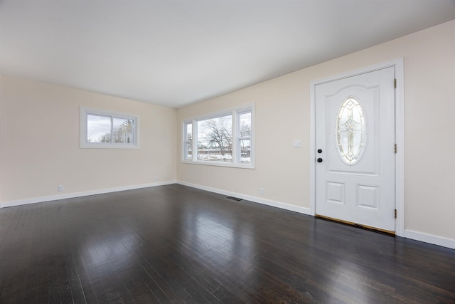 entryway with dark wood-type flooring, visible vents, and baseboards