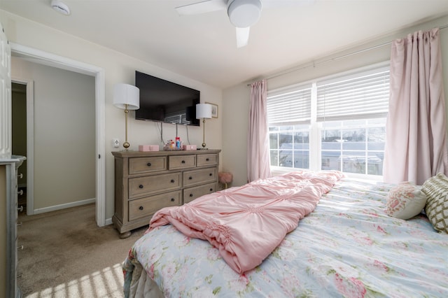 bedroom featuring baseboards, ceiling fan, and light colored carpet