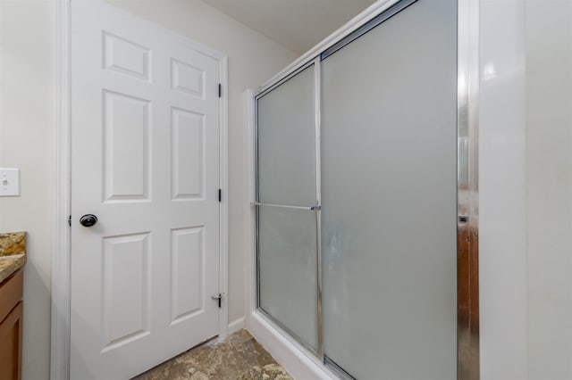 bathroom with a shower with shower door and vanity