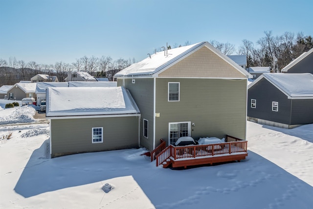 snow covered property with a wooden deck