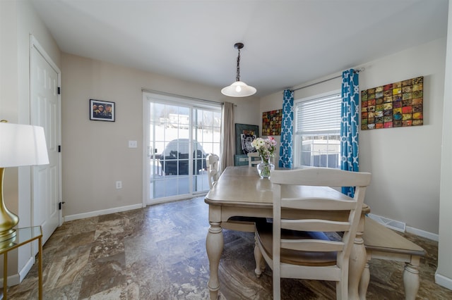 dining area featuring baseboards, visible vents, and a healthy amount of sunlight