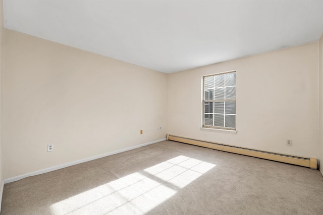 spare room featuring carpet floors, a baseboard radiator, and baseboards