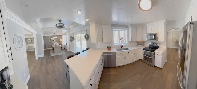 kitchen featuring stainless steel appliances, a sink, dark wood finished floors, and white cabinets