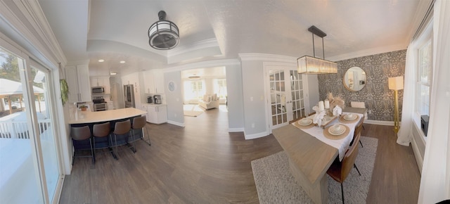 dining space featuring dark wood-style floors, wallpapered walls, baseboards, and crown molding