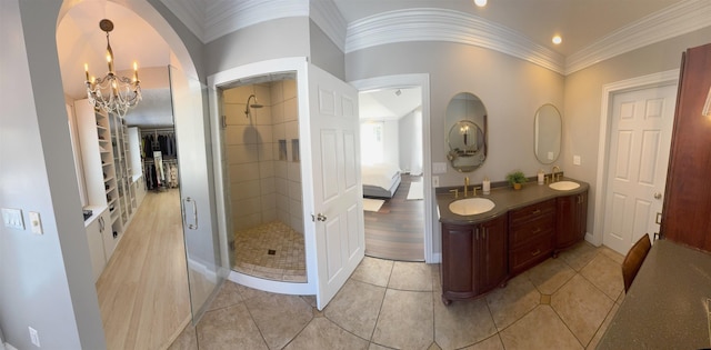 ensuite bathroom with ornamental molding, a stall shower, built in shelves, and an inviting chandelier