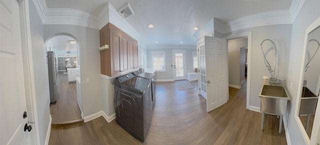 corridor with baseboards, arched walkways, wood finished floors, and ornamental molding