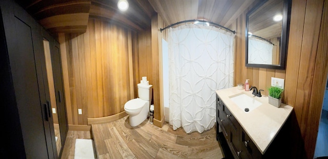 full bath featuring wooden walls, toilet, a shower with curtain, wood finished floors, and vanity