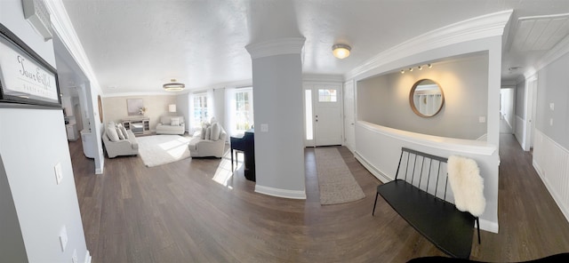 bedroom featuring baseboards, crown molding, ornate columns, and wood finished floors