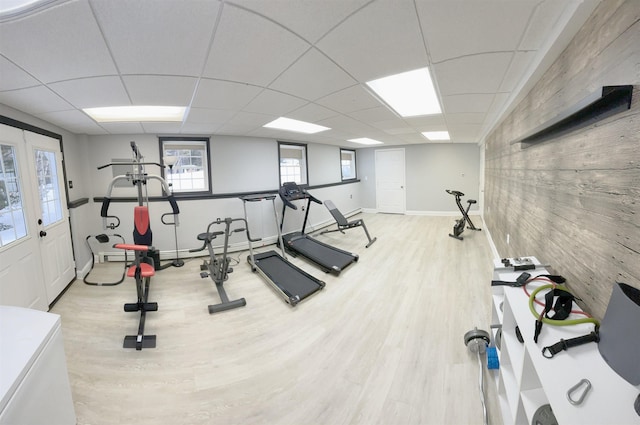 workout room with a drop ceiling, baseboards, and wood finished floors