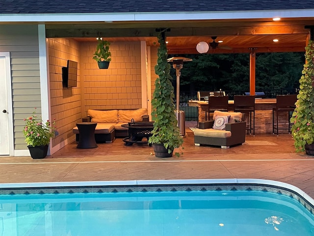 pool with a patio area and an outdoor hangout area