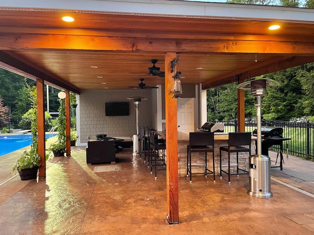 view of patio / terrace featuring ceiling fan, fence, outdoor dry bar, and area for grilling