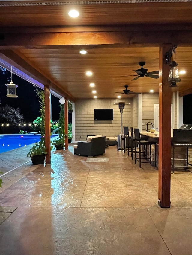 view of patio / terrace with an outdoor living space, a ceiling fan, and an outdoor pool