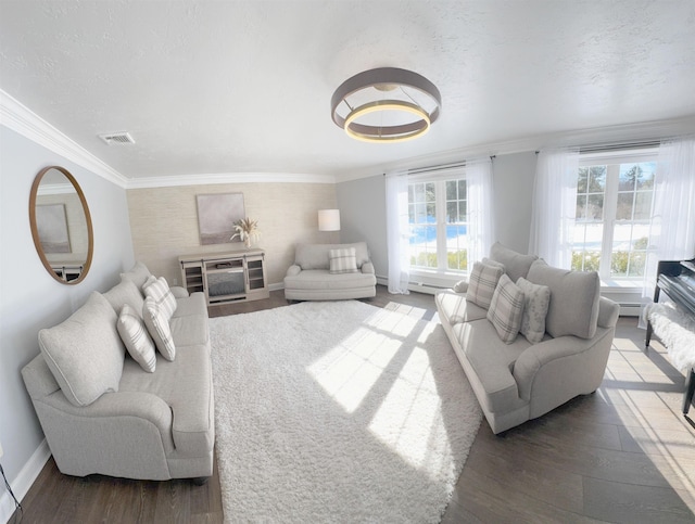 living area featuring plenty of natural light, wood finished floors, and crown molding