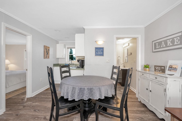 dining room featuring dark wood-style floors, ornamental molding, and baseboards