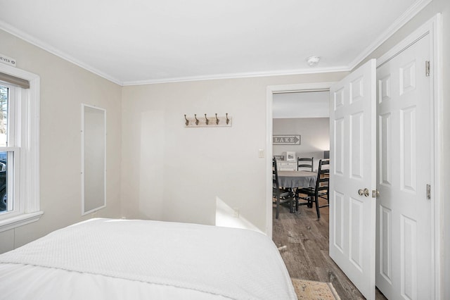 bedroom with wood finished floors and crown molding