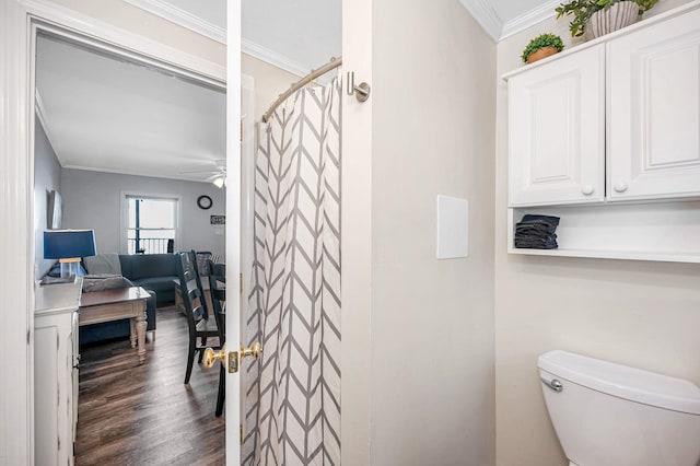 bathroom with ornamental molding, toilet, a shower with shower curtain, and wood finished floors