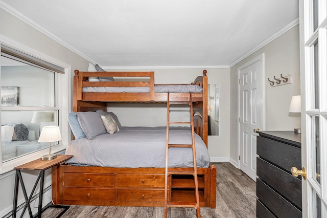 bedroom featuring ornamental molding, wood finished floors, and baseboards