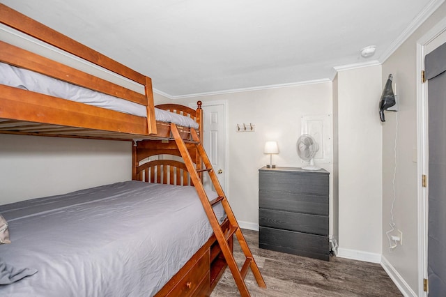 bedroom featuring dark wood-style floors, baseboards, and ornamental molding