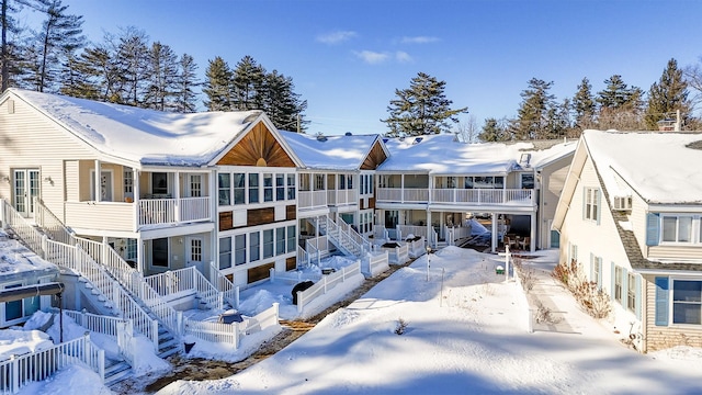 snow covered back of property with stairway