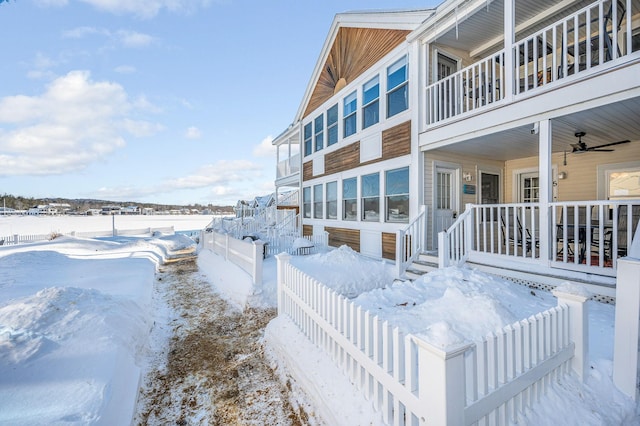 view of snow covered exterior with fence and a balcony