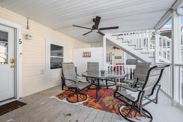 deck with outdoor dining space and ceiling fan