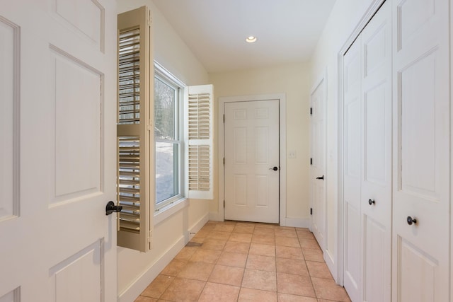 hallway with light tile patterned floors, baseboards, a wealth of natural light, and recessed lighting