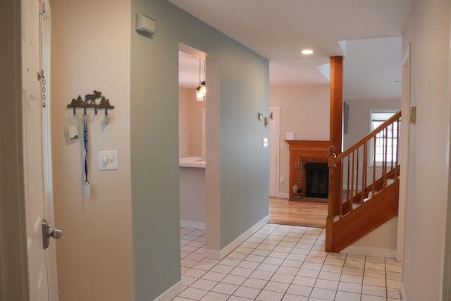 hallway featuring light tile patterned floors, stairs, baseboards, and recessed lighting