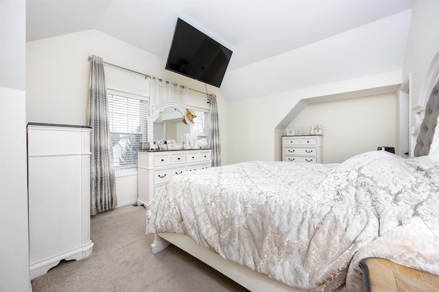 bedroom with vaulted ceiling and light colored carpet