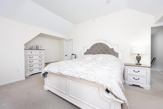 bedroom with lofted ceiling, light carpet, and baseboards