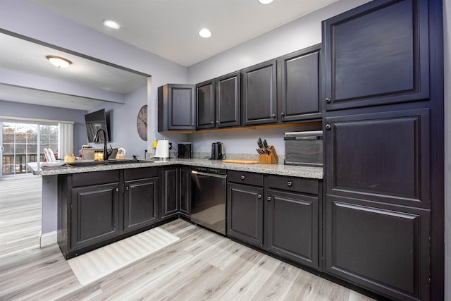 kitchen with light stone counters, a sink, light wood-type flooring, dishwasher, and a peninsula