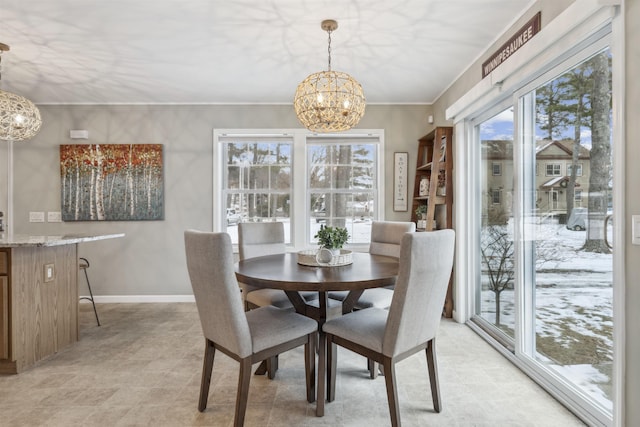 dining room featuring crown molding, baseboards, and a notable chandelier