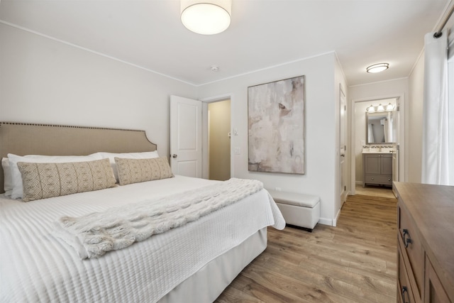 bedroom with light wood-style floors, ornamental molding, and baseboards