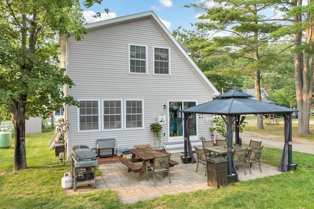 back of property featuring entry steps, a gazebo, a lawn, and a patio