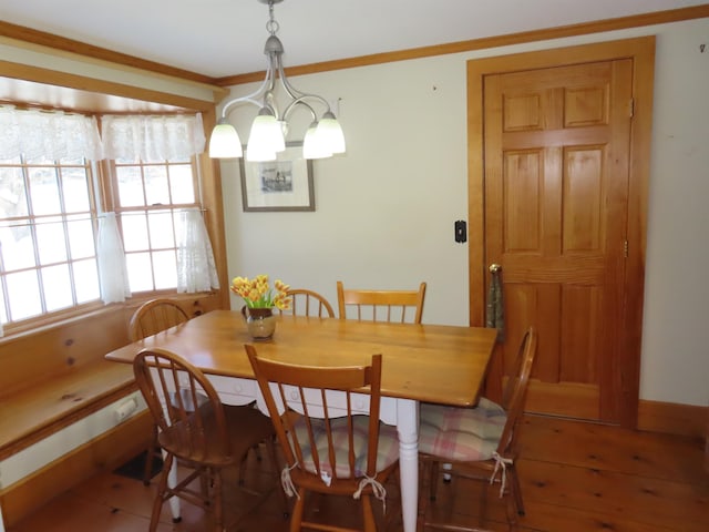 dining area with an inviting chandelier, baseboards, ornamental molding, and wood finished floors