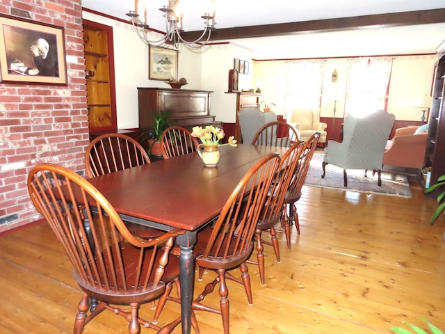 dining space featuring a notable chandelier, brick wall, hardwood / wood-style floors, and beamed ceiling