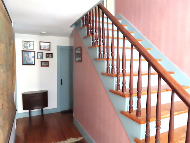 stairway with wood finished floors and baseboards