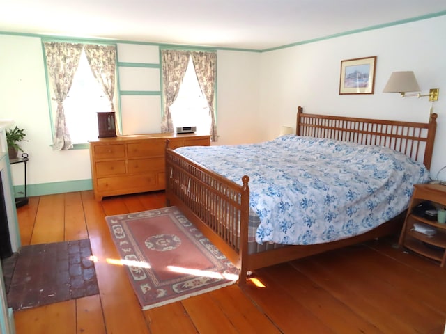 bedroom featuring hardwood / wood-style floors, multiple windows, and baseboards