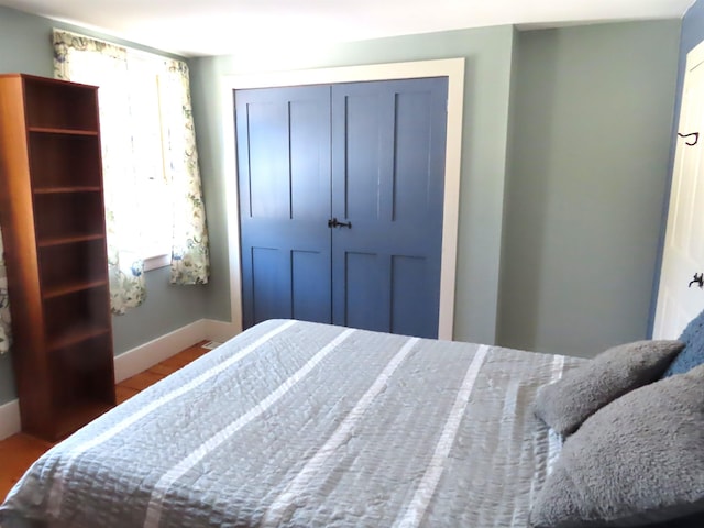 bedroom featuring a closet, baseboards, and wood finished floors