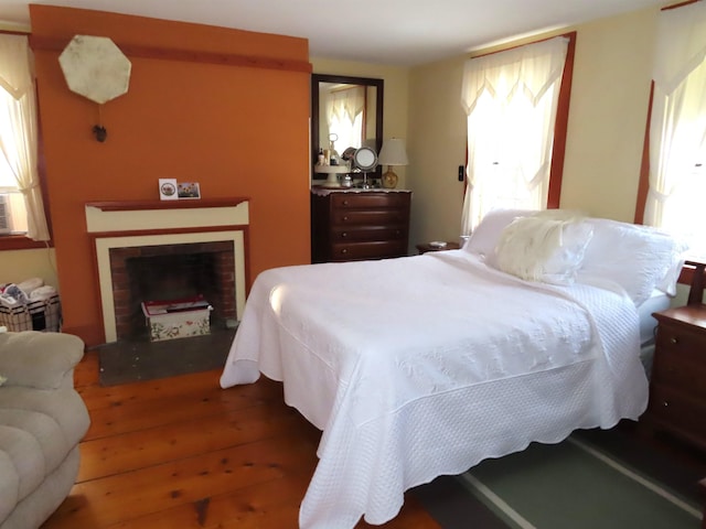 bedroom featuring a fireplace and hardwood / wood-style flooring