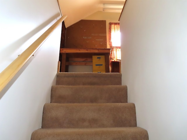 staircase featuring lofted ceiling