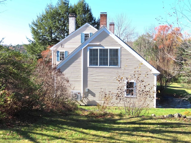 view of side of home featuring a yard and a chimney