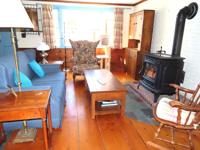 living room with a wood stove and wood-type flooring