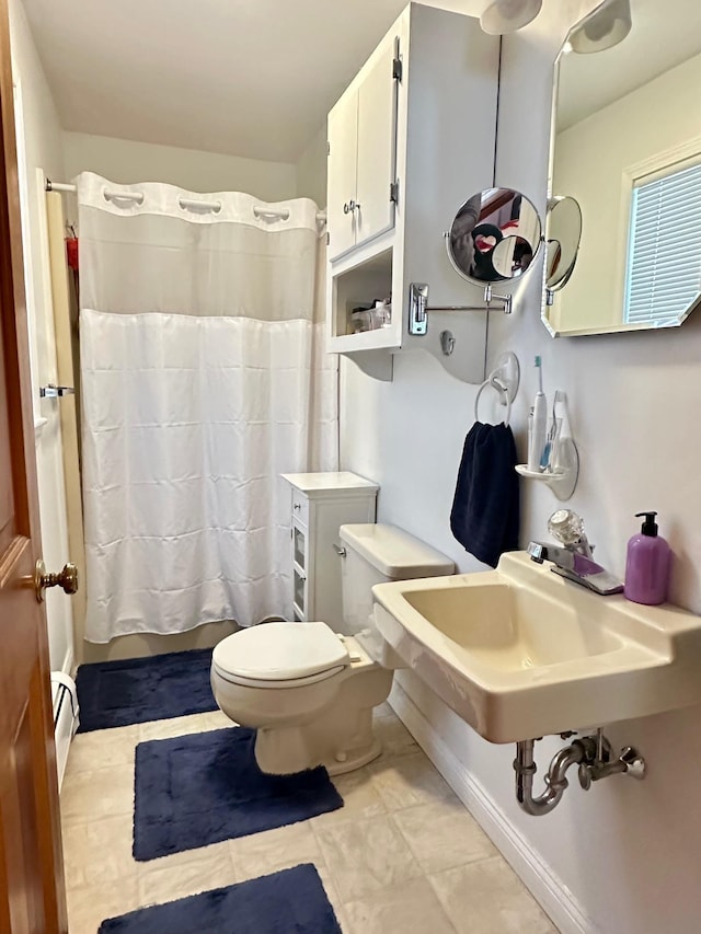 bathroom with tile patterned flooring, toilet, a baseboard heating unit, a sink, and a shower with curtain