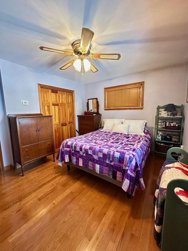 bedroom with a closet, wood finished floors, and a ceiling fan