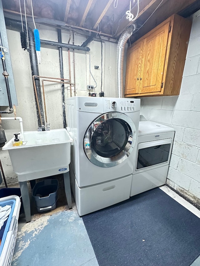 laundry room with washer and clothes dryer, a sink, and cabinet space