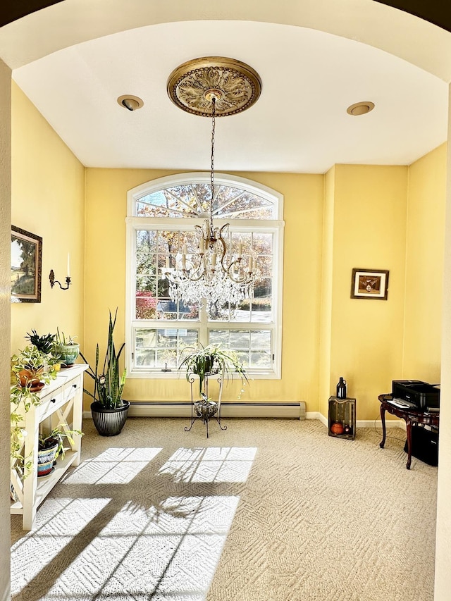 living area featuring an inviting chandelier, baseboards, a baseboard heating unit, and carpet flooring